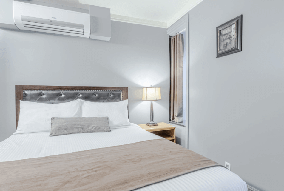 Acadia Hotel Quebec City – queen room with air conditioning, tufted headboard and bedside lamp