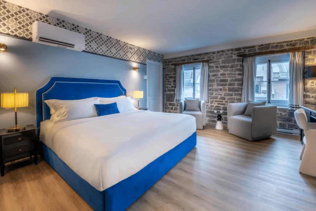 Avis chambre Acadia Delux Hotel Acadia Quebec avec grand lit King et mur de pierres